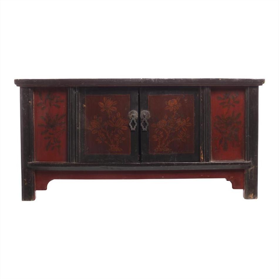 Red and black wooden coffee table with floral designs, two central doors, and lacquer accents, close-up view.