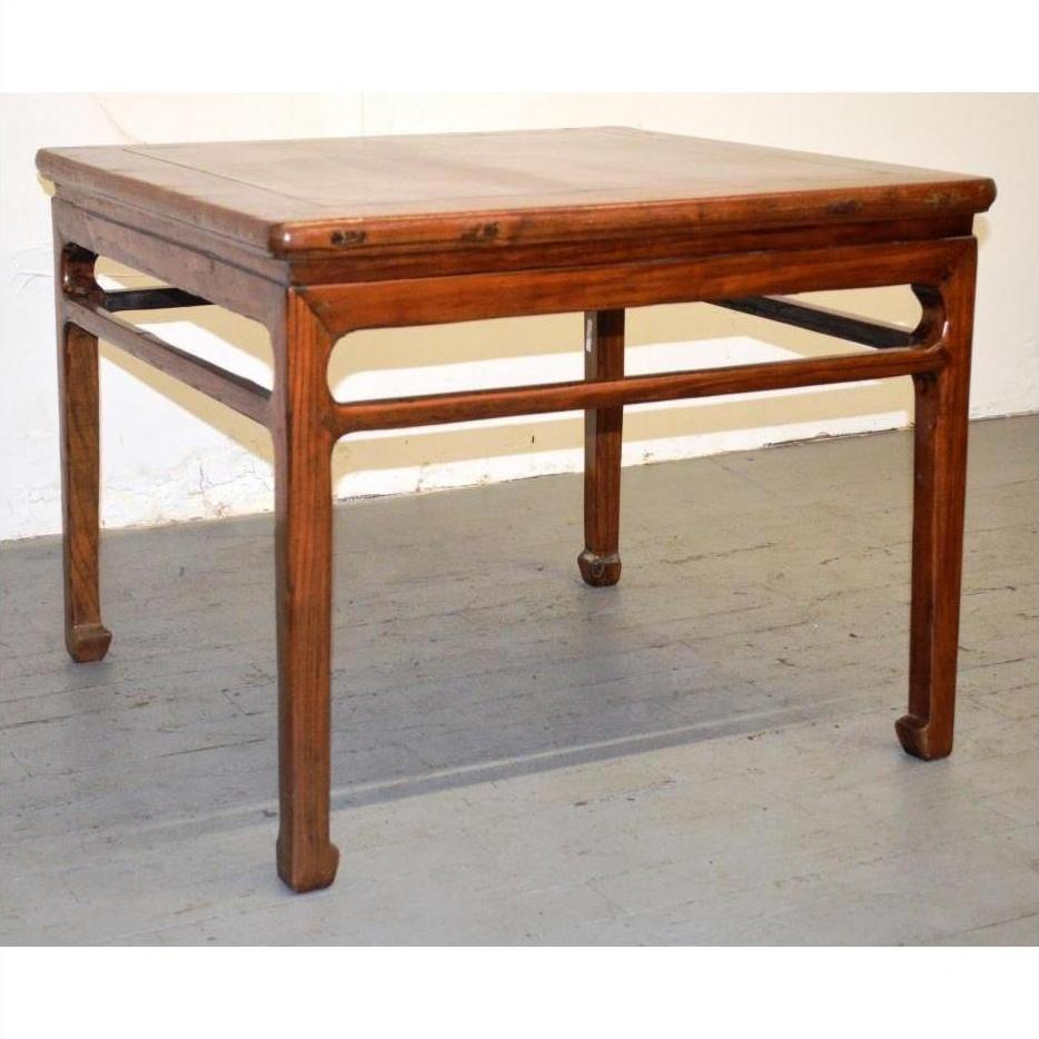Wood coffee or side table with straight legs and decorative apron on gray floor against a white wall.