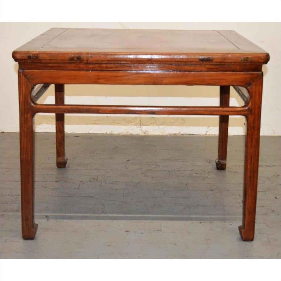 Rectangular wood coffee or side table with straight legs, positioned against a plain wall and floor.