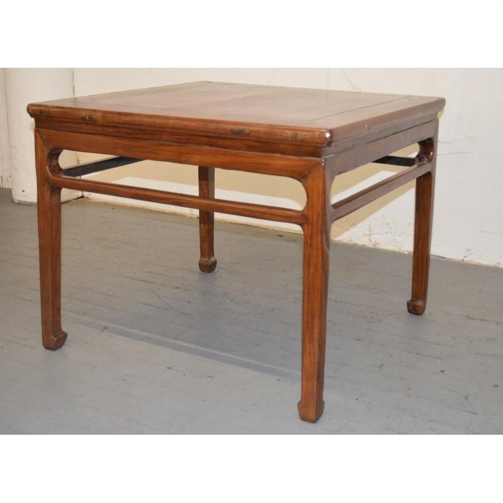 Square wooden coffee or side table with straight legs, minimalist design, on a gray floor.