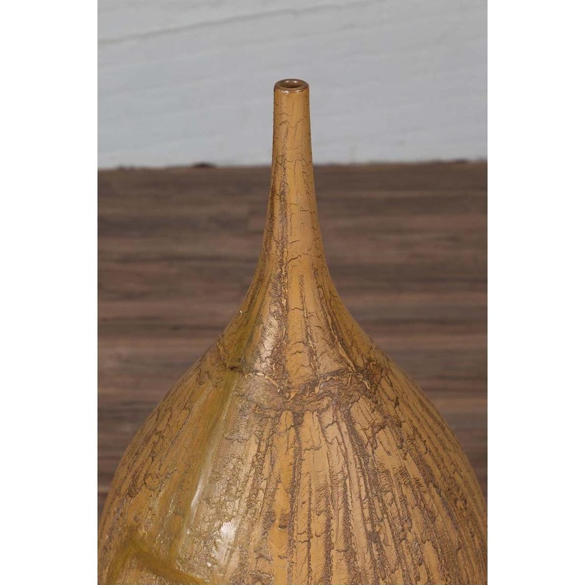 Mustard yellow ceramic vase with tapered spout on wooden surface.