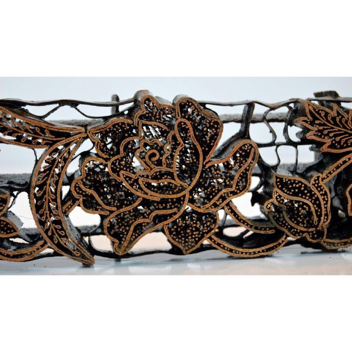 Copper batik ink block with intricate floral and central rose design, antique style, close-up view.