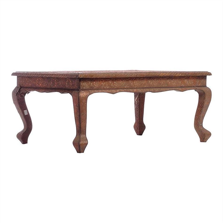 Copper coffee table with carved wooden legs and decorative patterns, displayed against a plain white background.