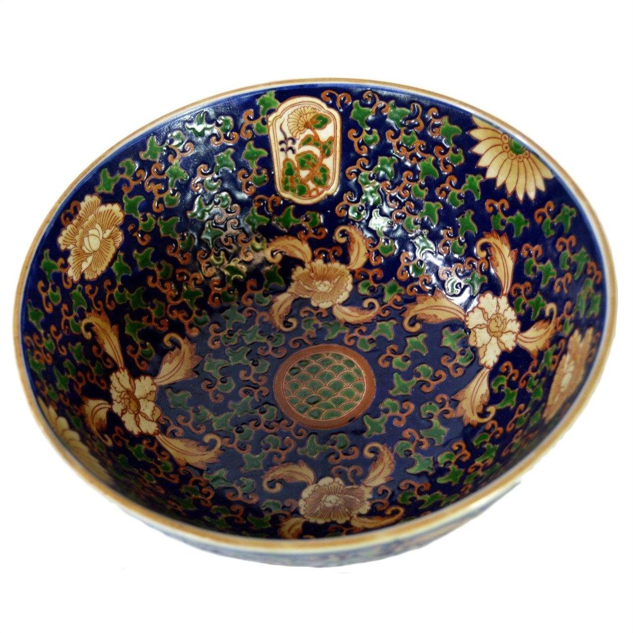 Close-up of blue, gold, green, and red Ming porcelain bowl with floral and bird patterns in very good condition.