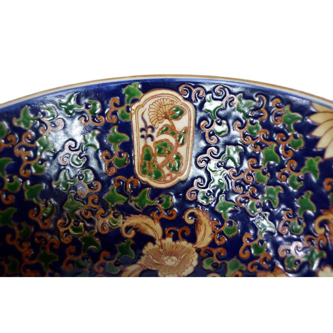 Close-up of a blue, gold, and green porcelain Ming bowl with intricate floral patterns, in very good condition.