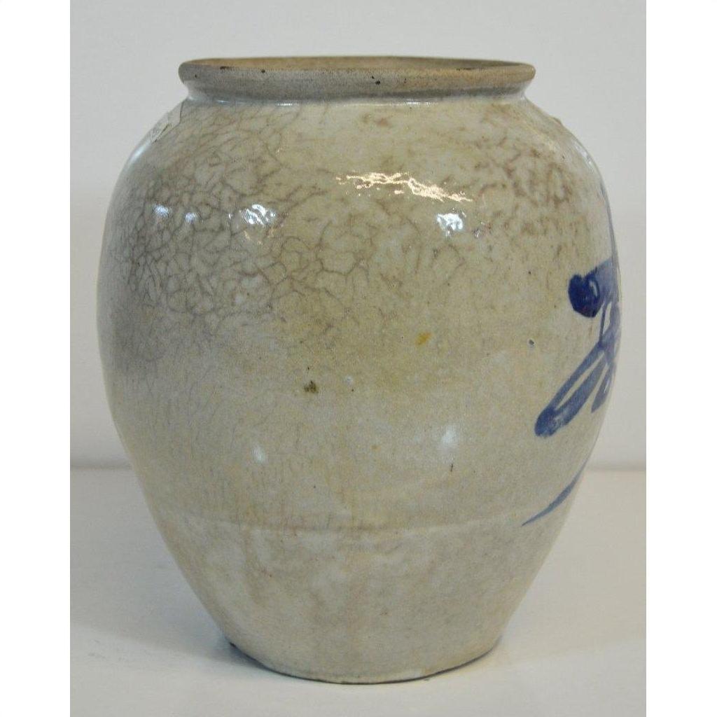 Close-up of round beige ceramic vase with fine crackle glaze and blue calligraphy, antique Japanese style.
