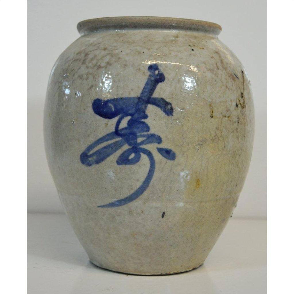 Close-up of a glossy blue and white Japanese crackle vase with bold abstract brushstroke on the front.