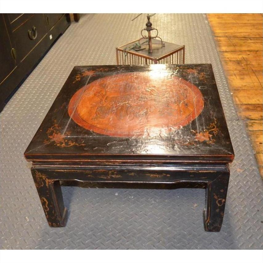 Black lacquer wood Kang table with horse hoof feet, painted Asian-style design, on a patterned floor.