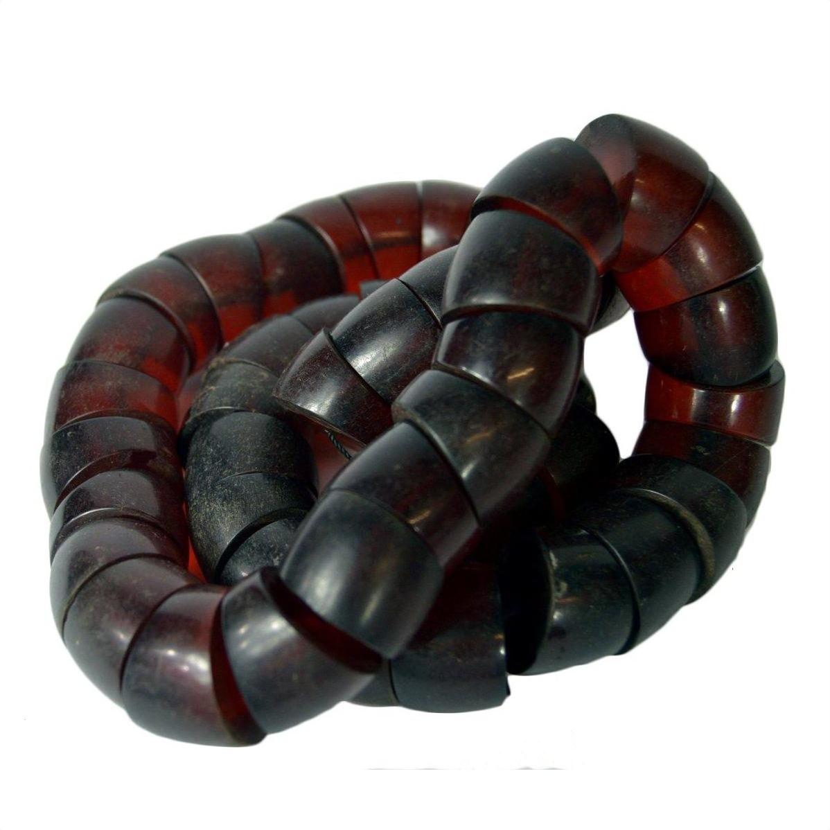 Close-up of a dark red and black resin Dragon Blood Amber necklace with a segmented, curved design.