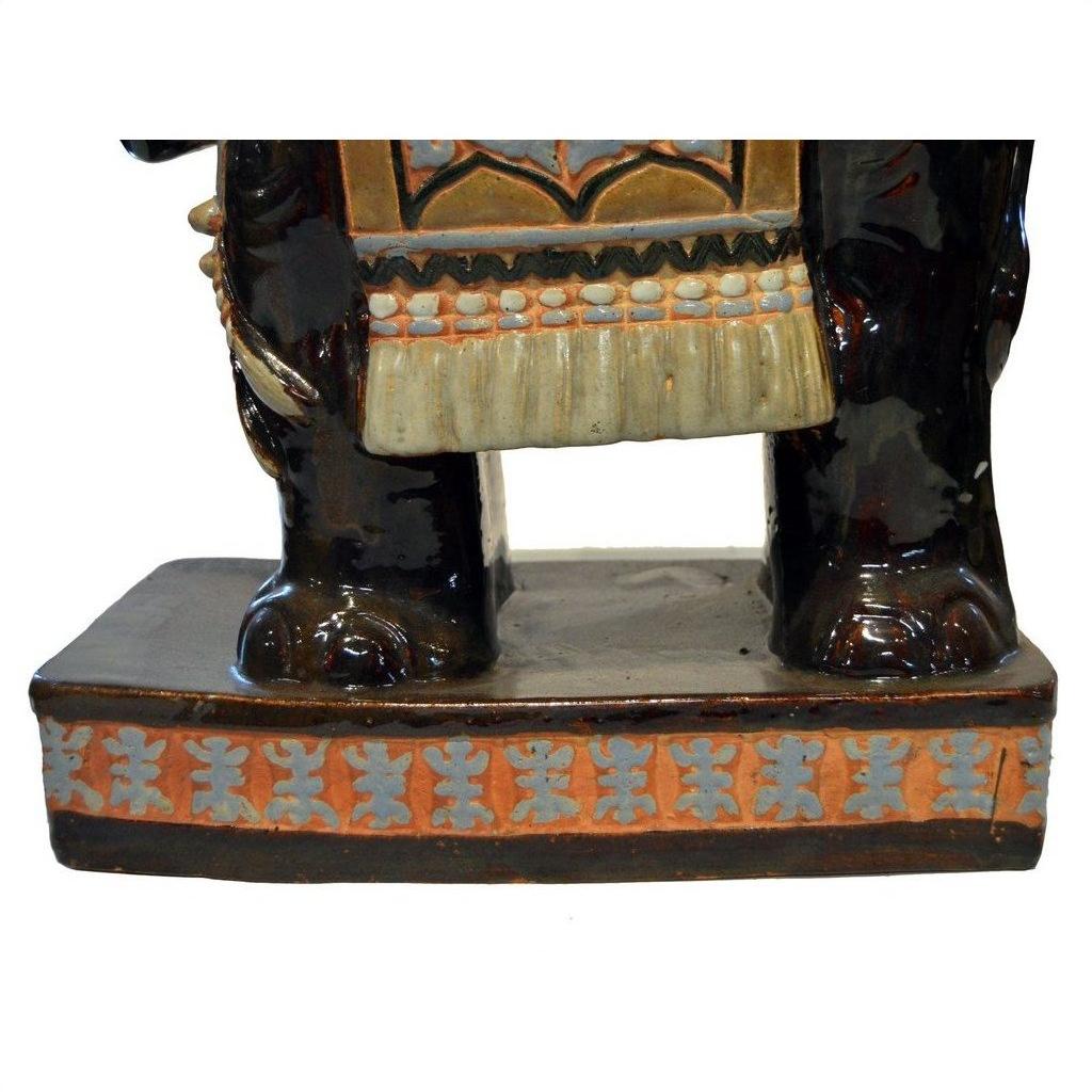 Painted ceramic elephant garden stool with dark-colored elephant-like lower legs, close-up view.
