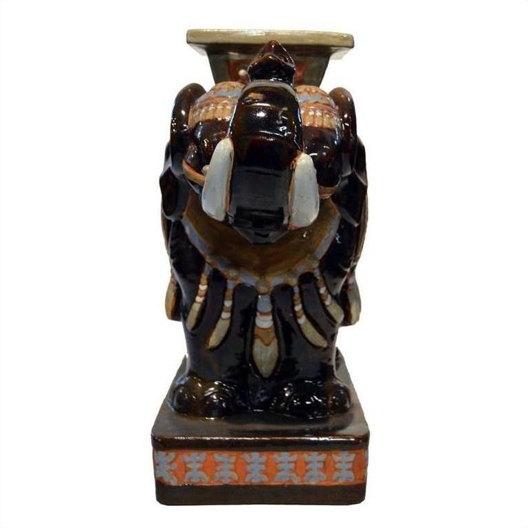 White ceramic elephant garden stool with decorative saddle, rectangular base, front view.