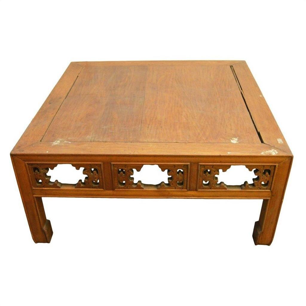 Brown elm wood coffee table with hand-carved designs and slightly tapered legs in antique Chinese style.