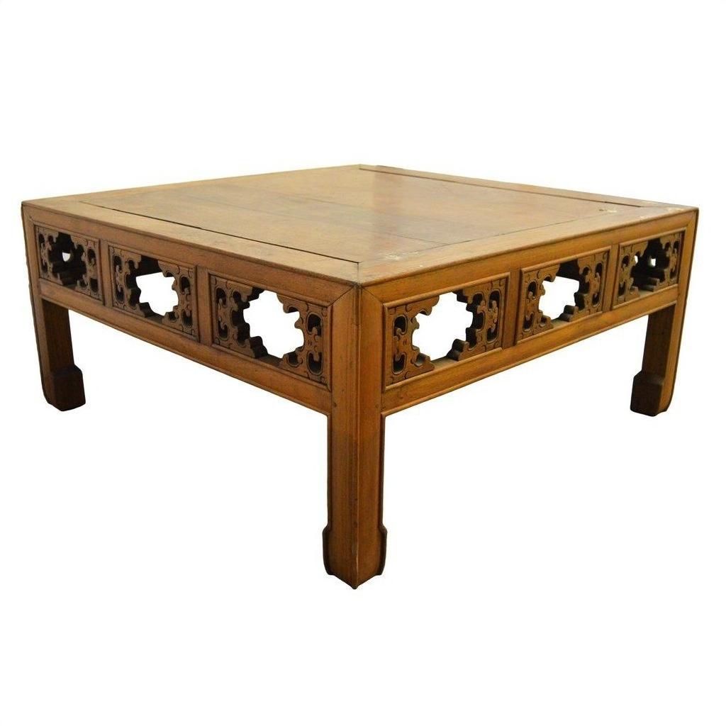 Natural elm wood coffee table with carved latticework sides and sturdy, slightly tapered legs.
