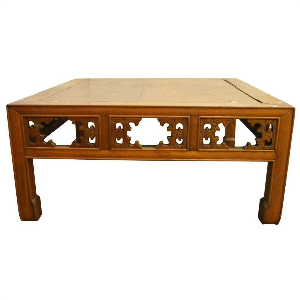 Light brown elm wood coffee table with hand-carved designs and sturdy square legs on white background.