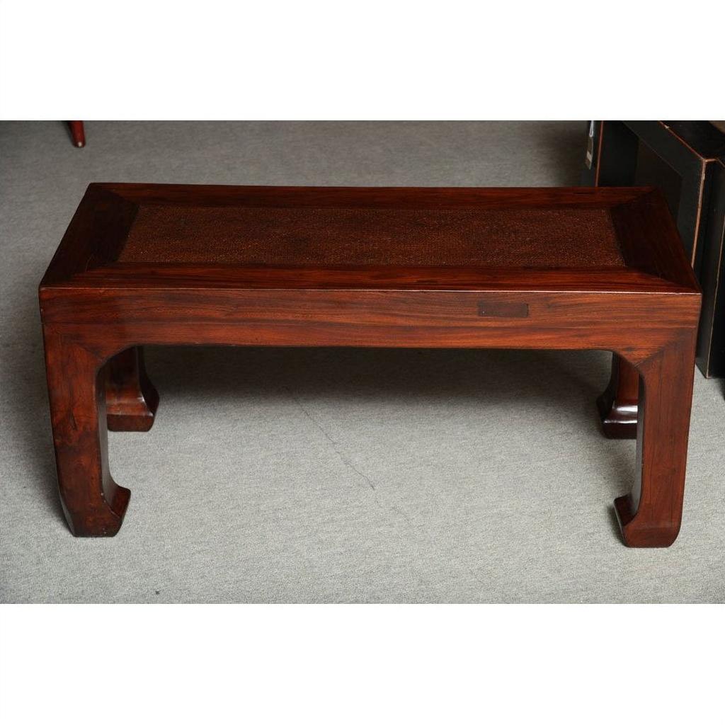 Antique elm wood table with curved legs on grey carpeted floor.