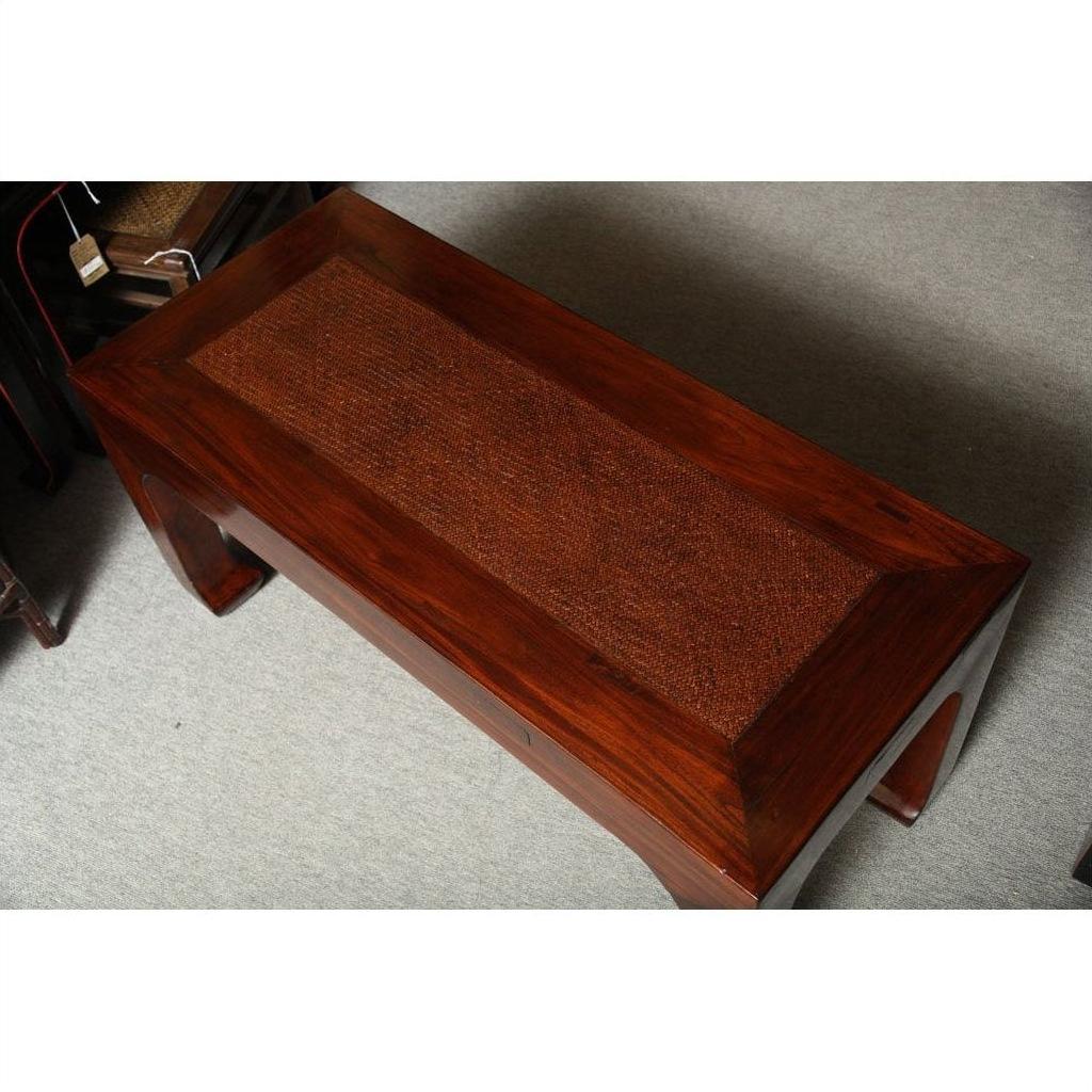 Brown antique elm wood table with curved legs and woven rattan top, set on a carpeted floor.