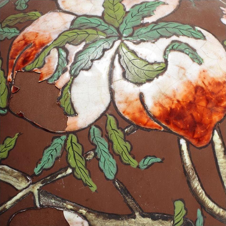 Close-up of a vintage Chinese ceramic flower vase with floral design, cracked glaze, and chipped paint.
