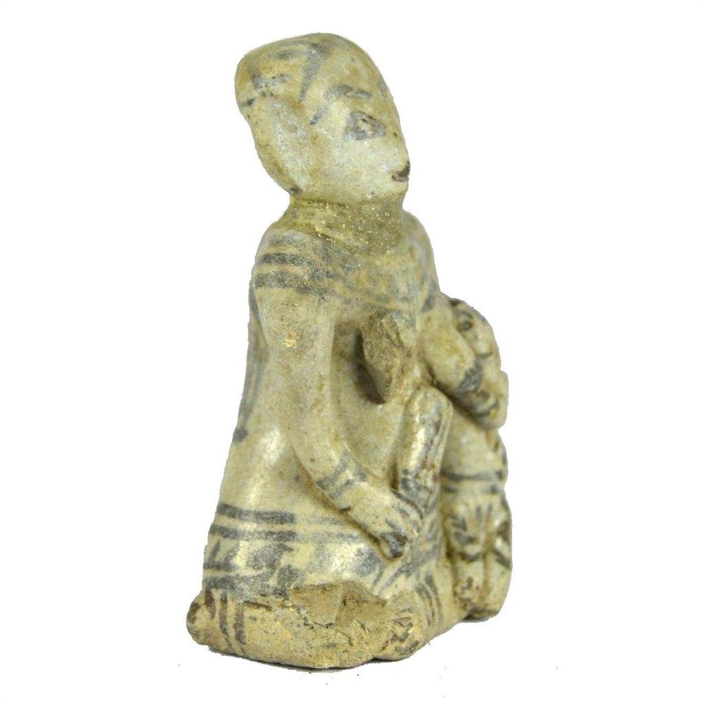 Close-up of glazed terracotta fertility doll, seated figure with child, light material and dark accents.