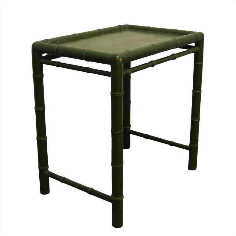 Close-up of a green bamboo-style side table with legs and edges designed to resemble bamboo stalks.