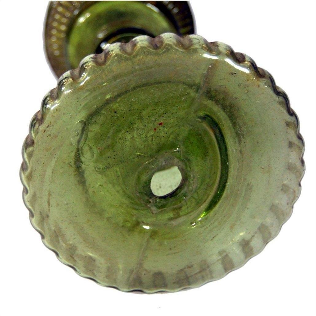 Green glass oil lamp base with scalloped edge and raised center, close-up from below, very good condition.
