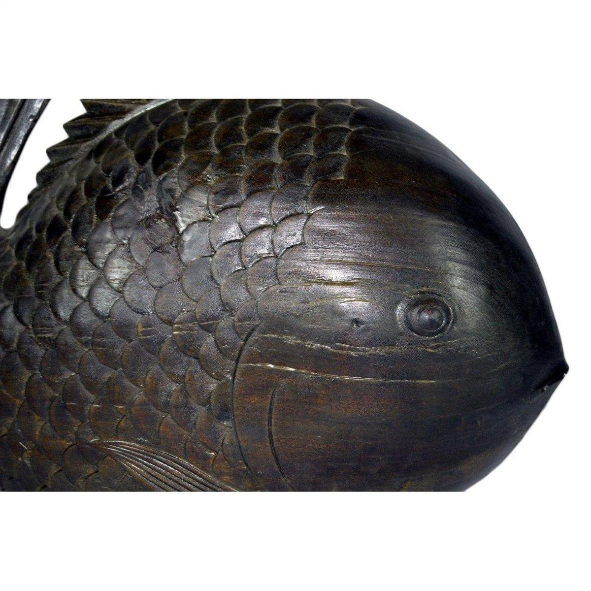 Close-up of dark wood hand-carved fish sculpture with detailed scales and one visible eye, in good condition.