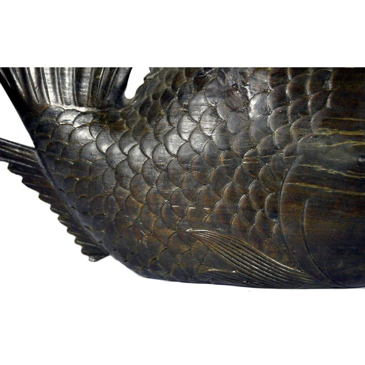 Close-up of bronze hand carved fish sculpture with detailed scales and fins on white background.