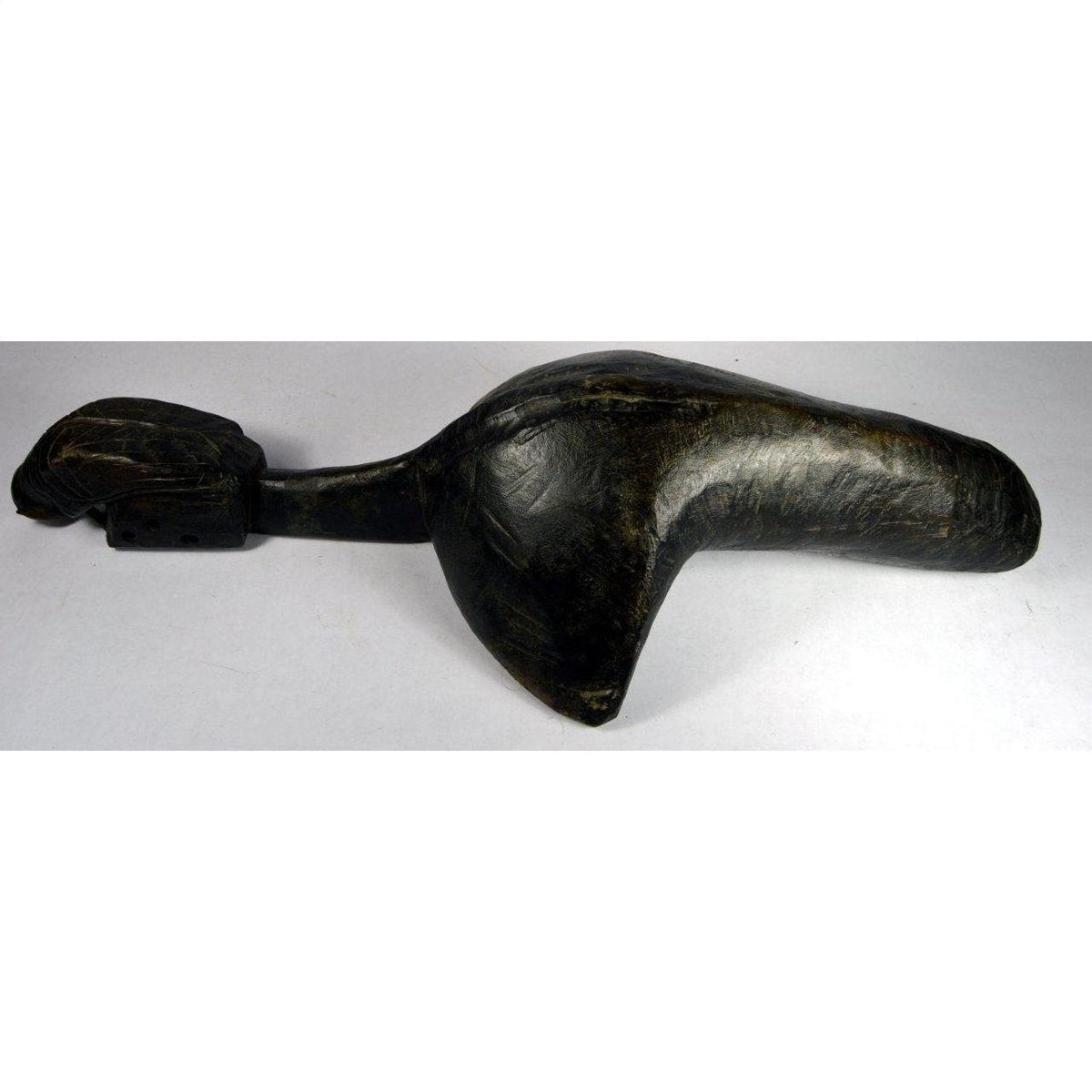 Close-up of a dark wood hand-carved Saringda lute in a stylized bird shape, inspired by Northern India folk fiddles.