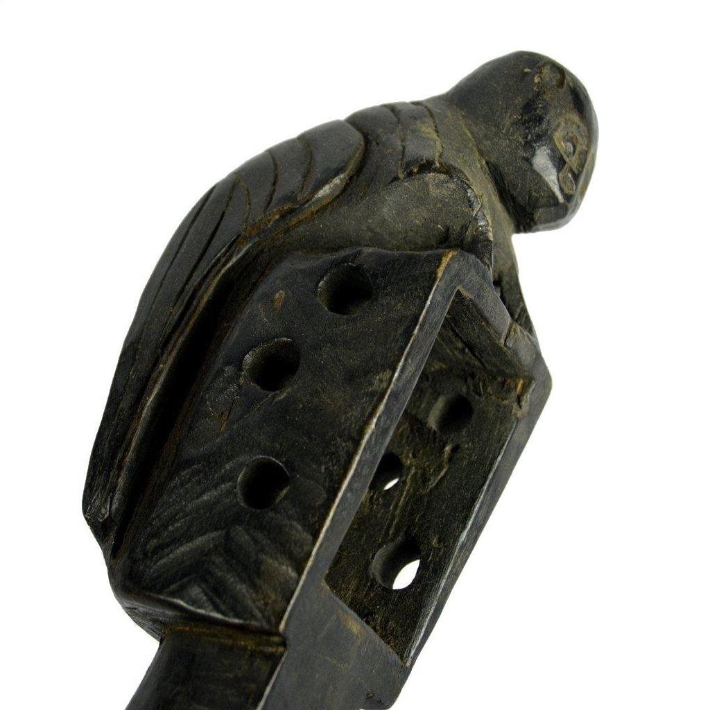 Brown wooden lute with a carved bird on top, rectangular base with holes, shown close-up.