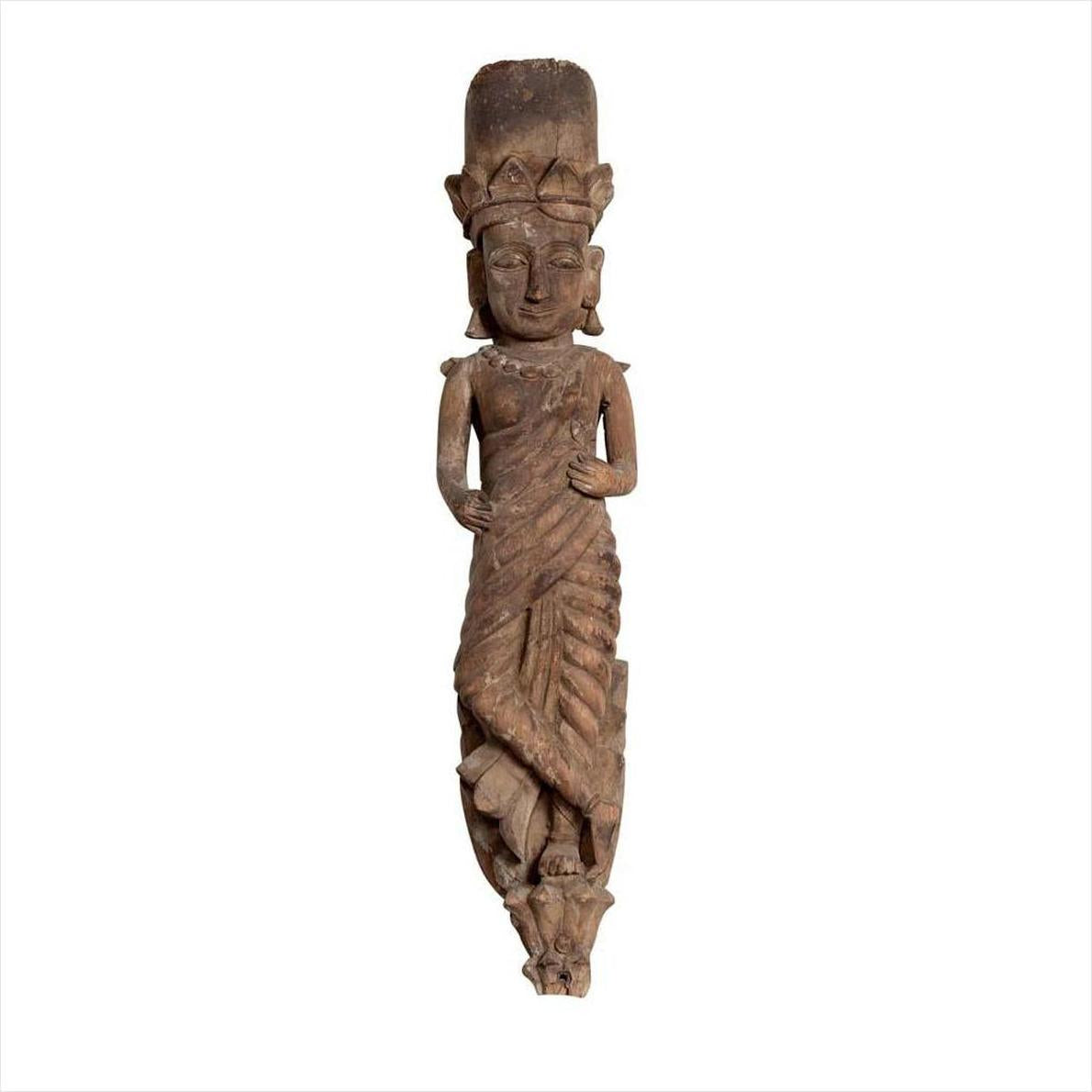 Brown carved wood statue of crowned Hindu deity in draped garment, on white background.
