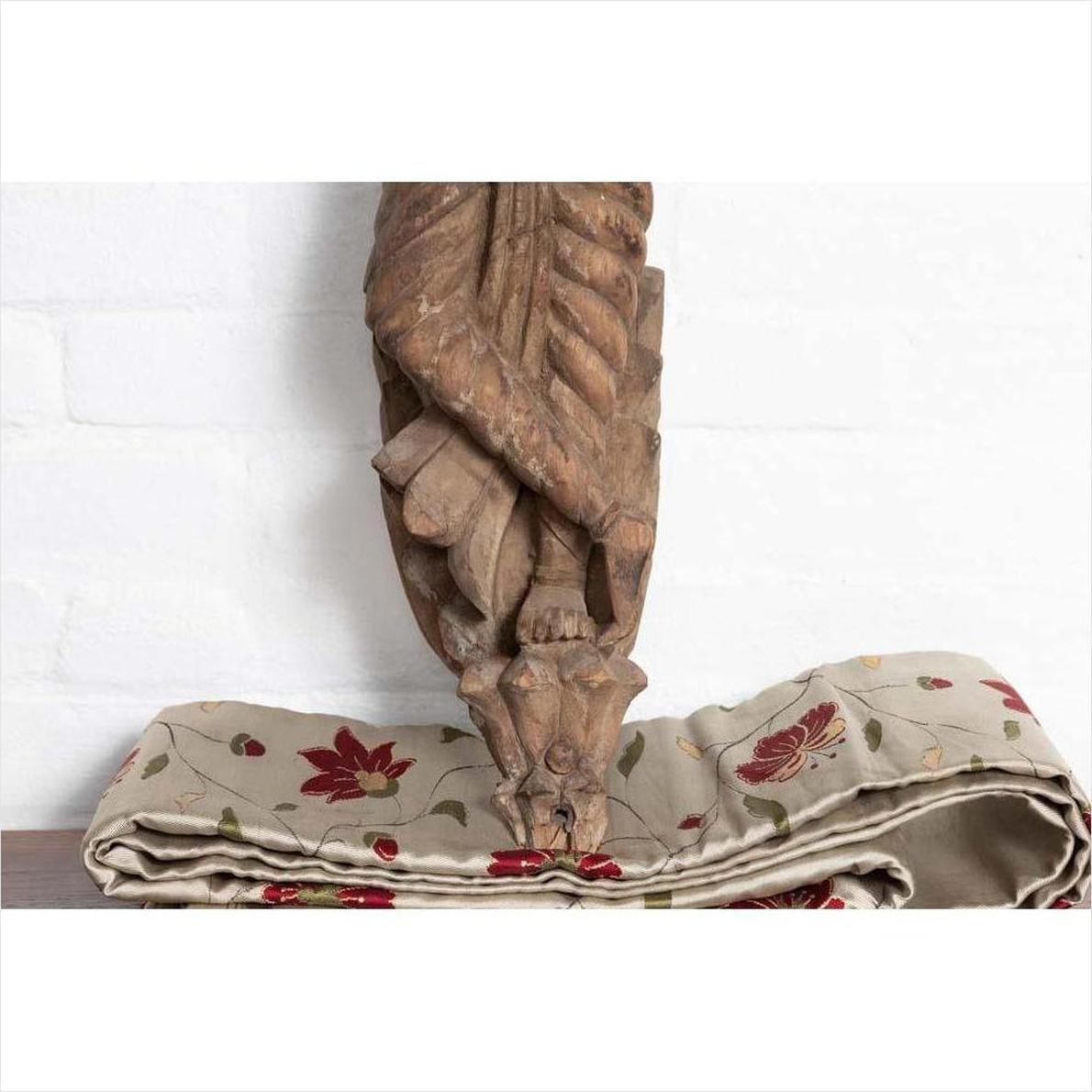 Brown stone hand carved Indian temple statue of Hindu deity from Gujarat, traditional design, on plain background.