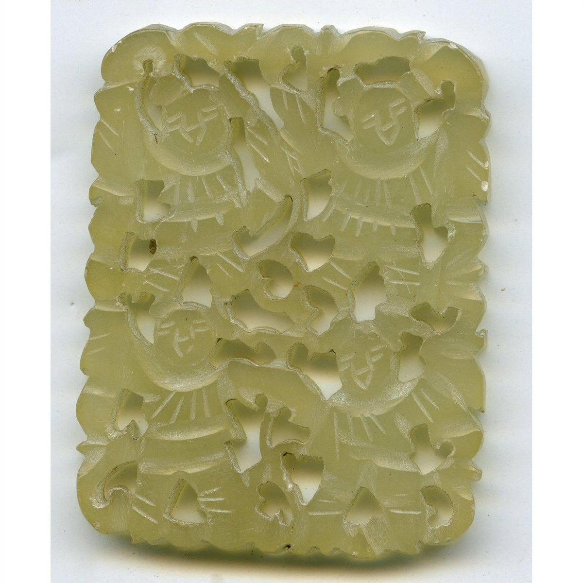 Green jade medallion, hand carved with four stylized human figures and patterns, close-up, 2-inch size comparison.