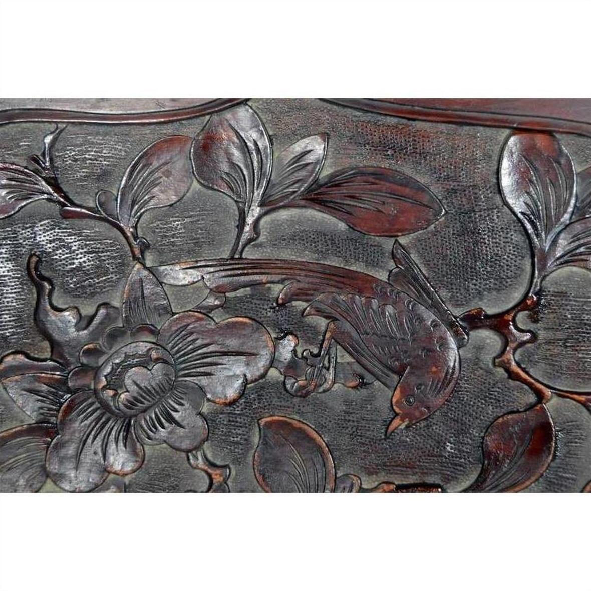 Close-up of a hand-carved lacquered rosewood 19th-c. Chinese wall plaque with bird, branch, leaves, and flower.