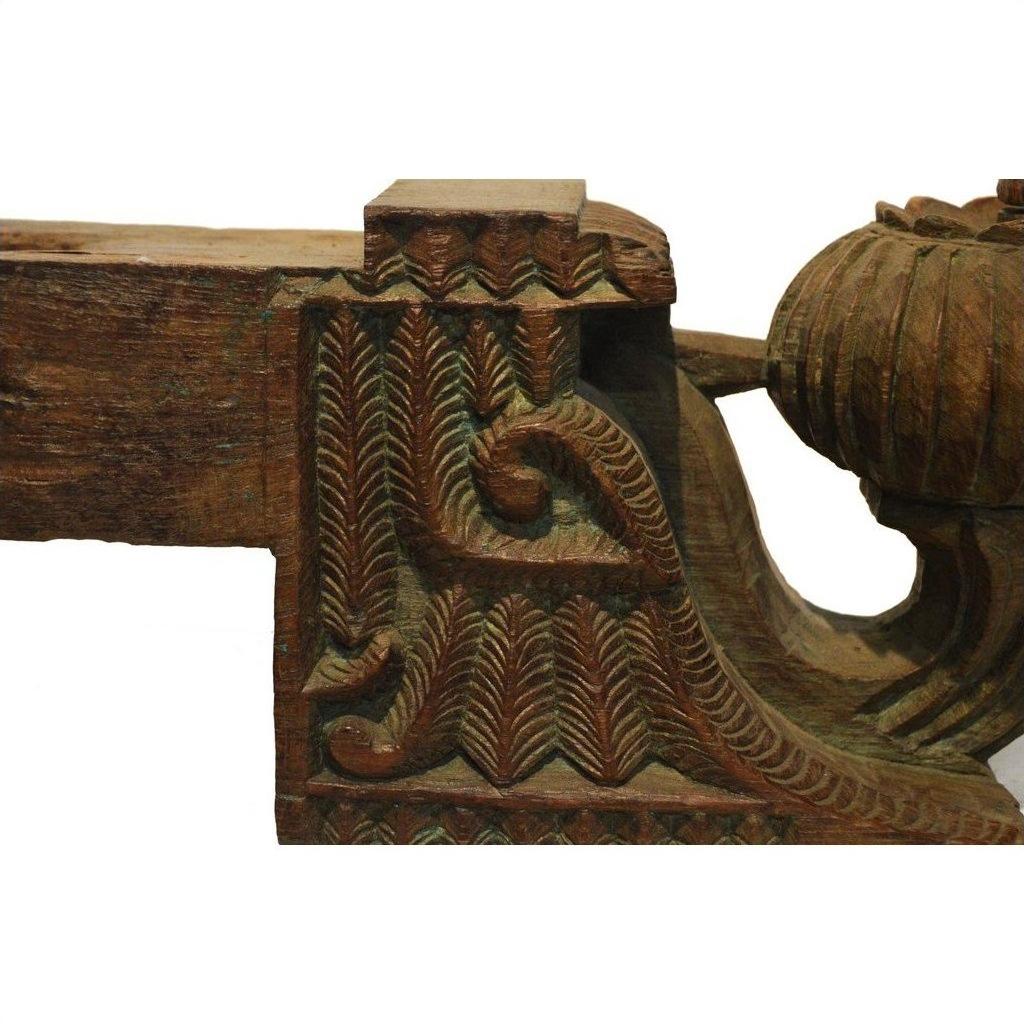 Close-up of brown teak wood architectural element with intricate carved patterns and decorative motifs.
