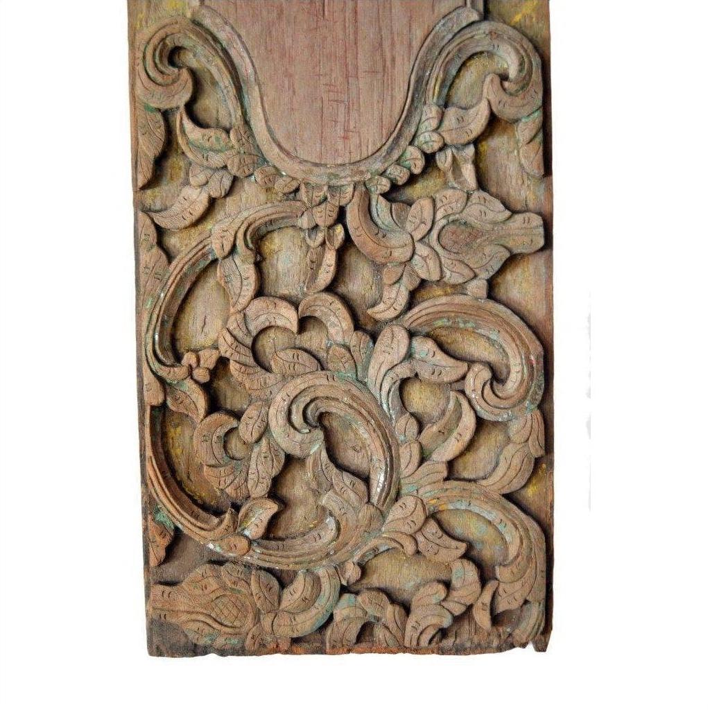 Brown wood hand carved wall plaque with intricate swirling floral and leaf patterns, weathered finish, close-up view.