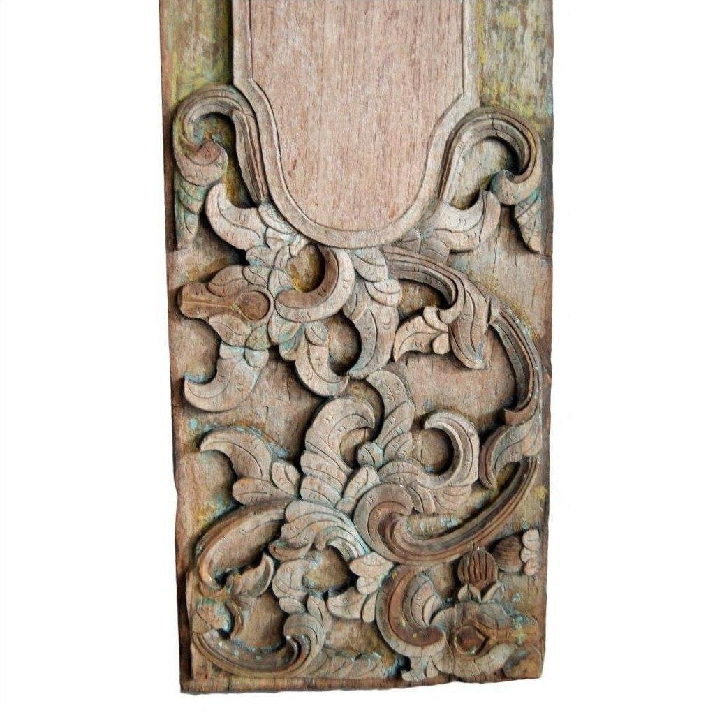 Brown wood rectangular wall plaque with hand-carved swirling floral and leaf motifs, close-up view.