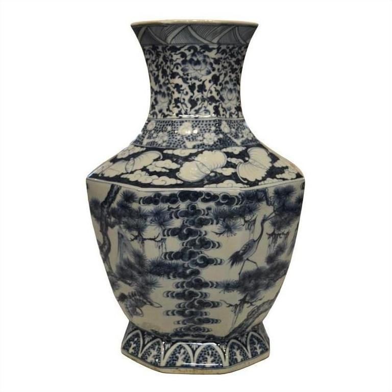 Blue and white porcelain vase with hand-painted birds, trees, and clouds patterns.