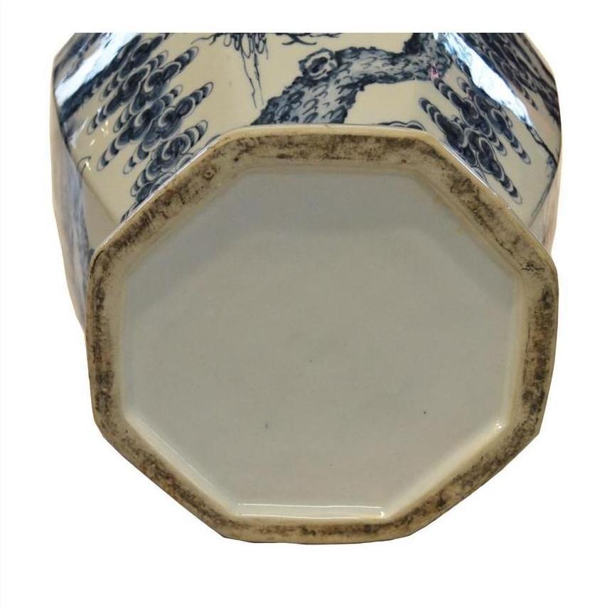 Blue and white porcelain vase with octagonal base, close-up showing decorative side motifs.