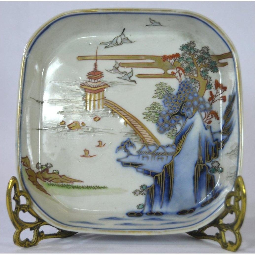 Multicolor porcelain Imari bowl with hand painted Asian landscape, figure, trees, birds, and pagoda by water.