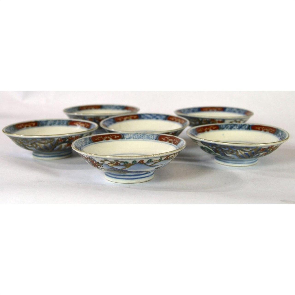 Blue, red, and gold porcelain Imari small plates set of 6 displayed on a white surface.