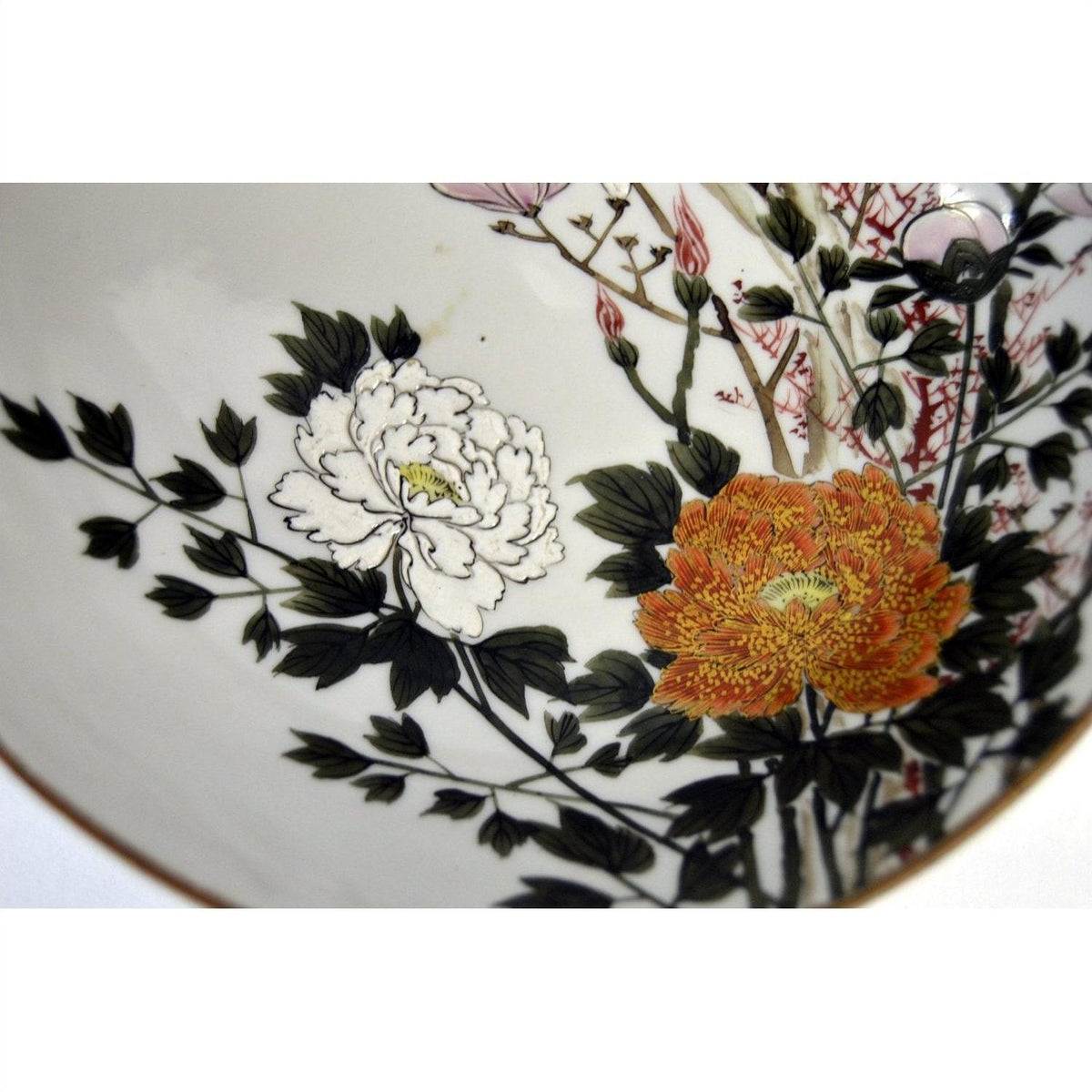 Close-up of a white porcelain Kutani bowl with hand painted orange peonies and green leaves, 7-inch diameter.
