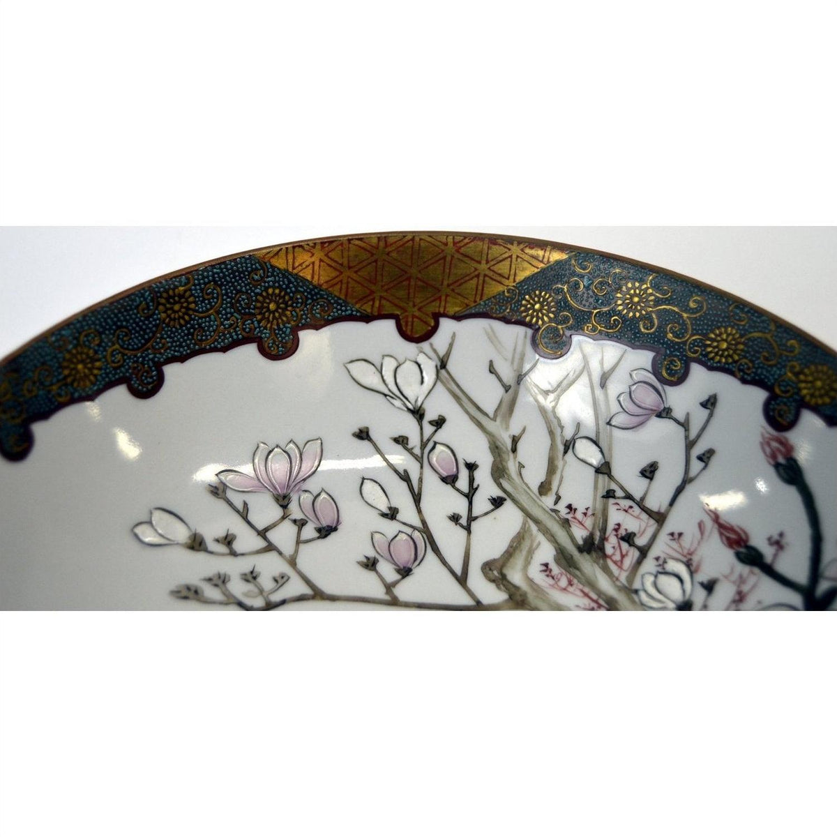 Blue and gold rimmed Kutani porcelain bowl with pink magnolia flowers, 7 inch diameter, close-up.