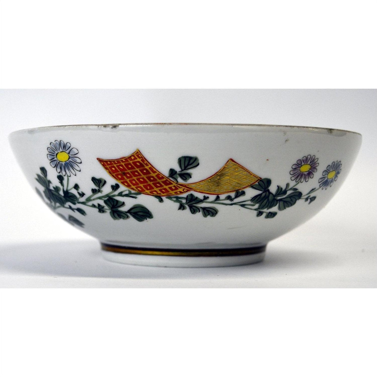Yellow and red porcelain bowl with white daisy and green leaf pattern, 7 inch diameter, on plain background.