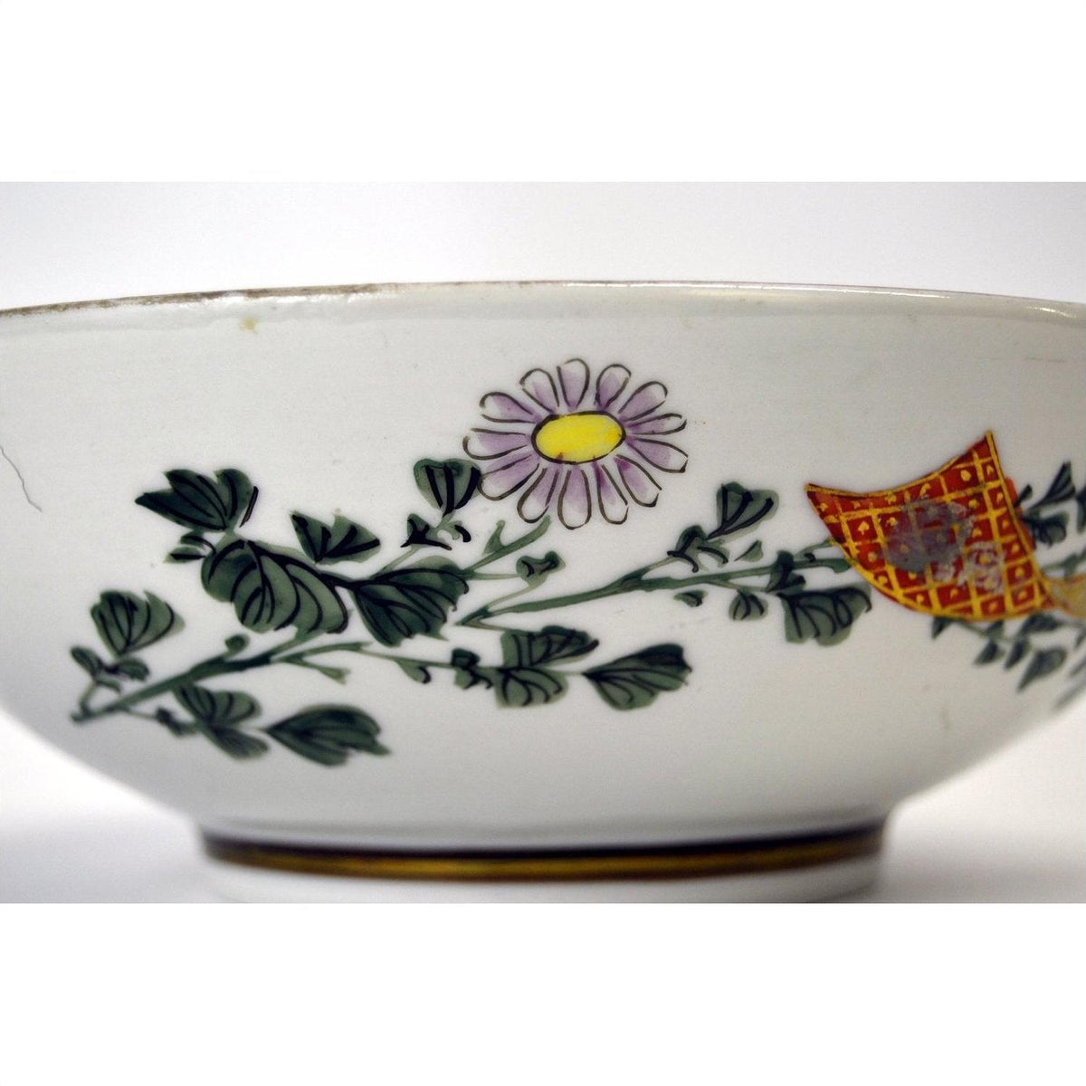 Porcelain bowl with green leaves, purple-yellow flower, and red-yellow geometric pattern, 7-inch diameter.