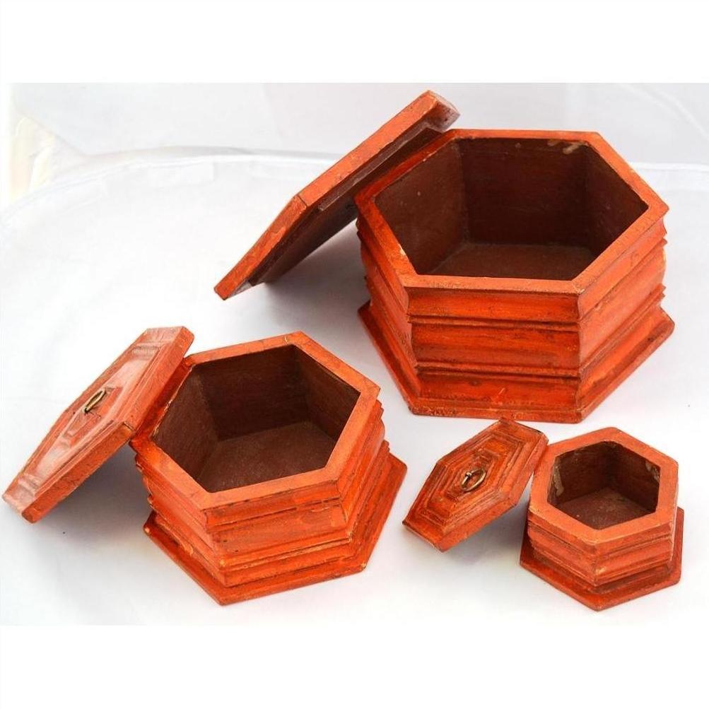 Close-up of three hand painted octagonal boxes with lids, nested together on a white background.