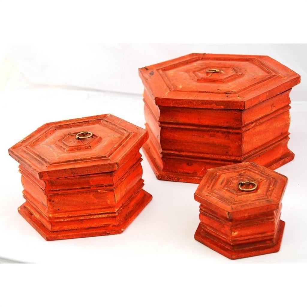 Close-up of three hand painted octagonal boxes with lids and metal ring handles on a white surface.