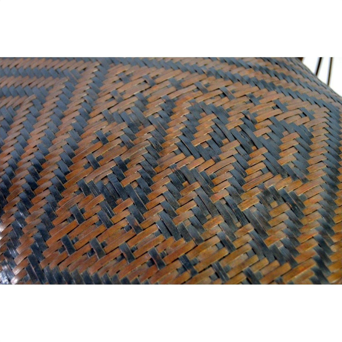 Close-up of a brown and black rattan basket with geometric pattern.