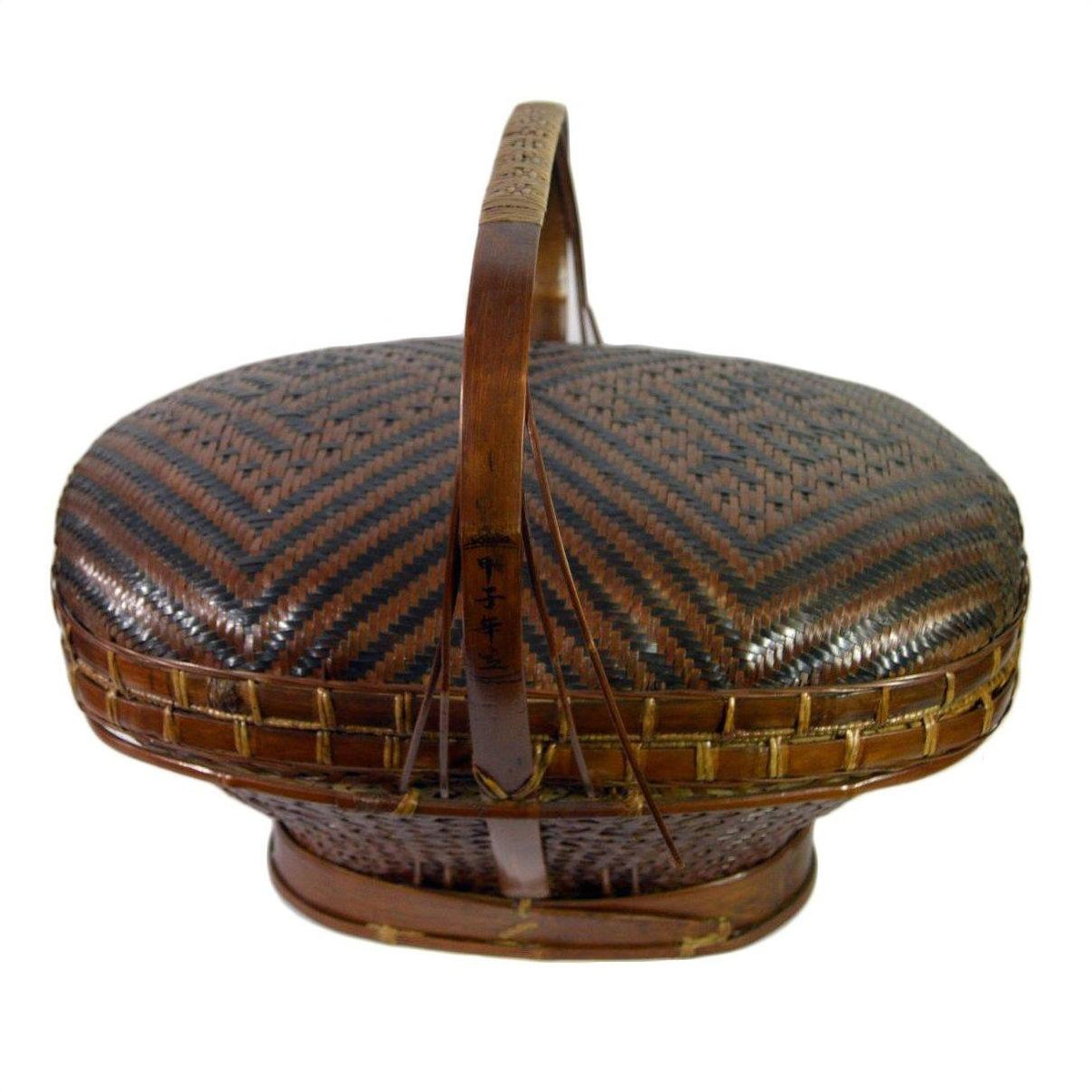 Close-up of dark and light brown rattan basket with chevron pattern, lid, and curved handle.
