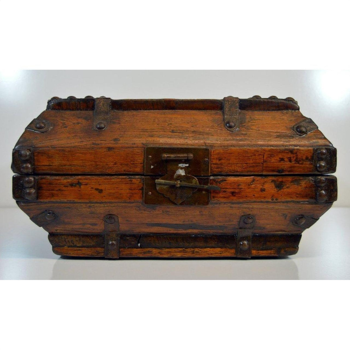 Close-up of a vintage brown lacquer wood Chinese box with iron hardware and central front latch.