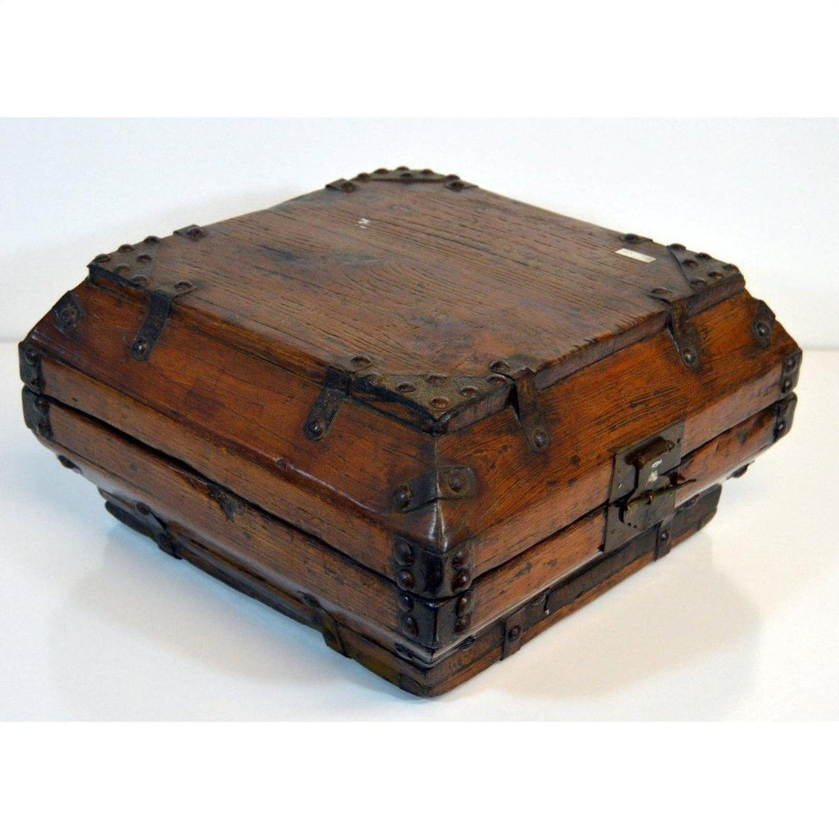 Close-up of vintage brown lacquer Chinese box with iron hardware and latch, closed on a white background.