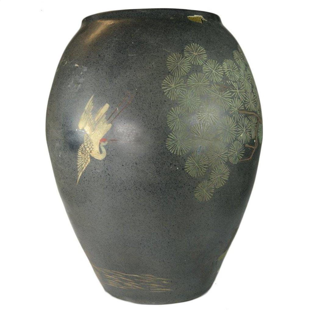 Close-up of dark ceramic Hong Kong vase with hand-painted crane, pine tree, gold details, minor paint loss visible.